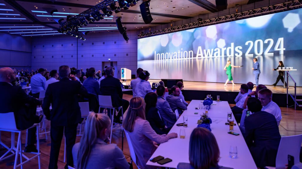 Automechanika Frankfurt Innovation Awards -palkintogaala Festhallen AMBITION-lavalla, taustalla suuri Innovation Awards -näyttöteksti ja yleisö